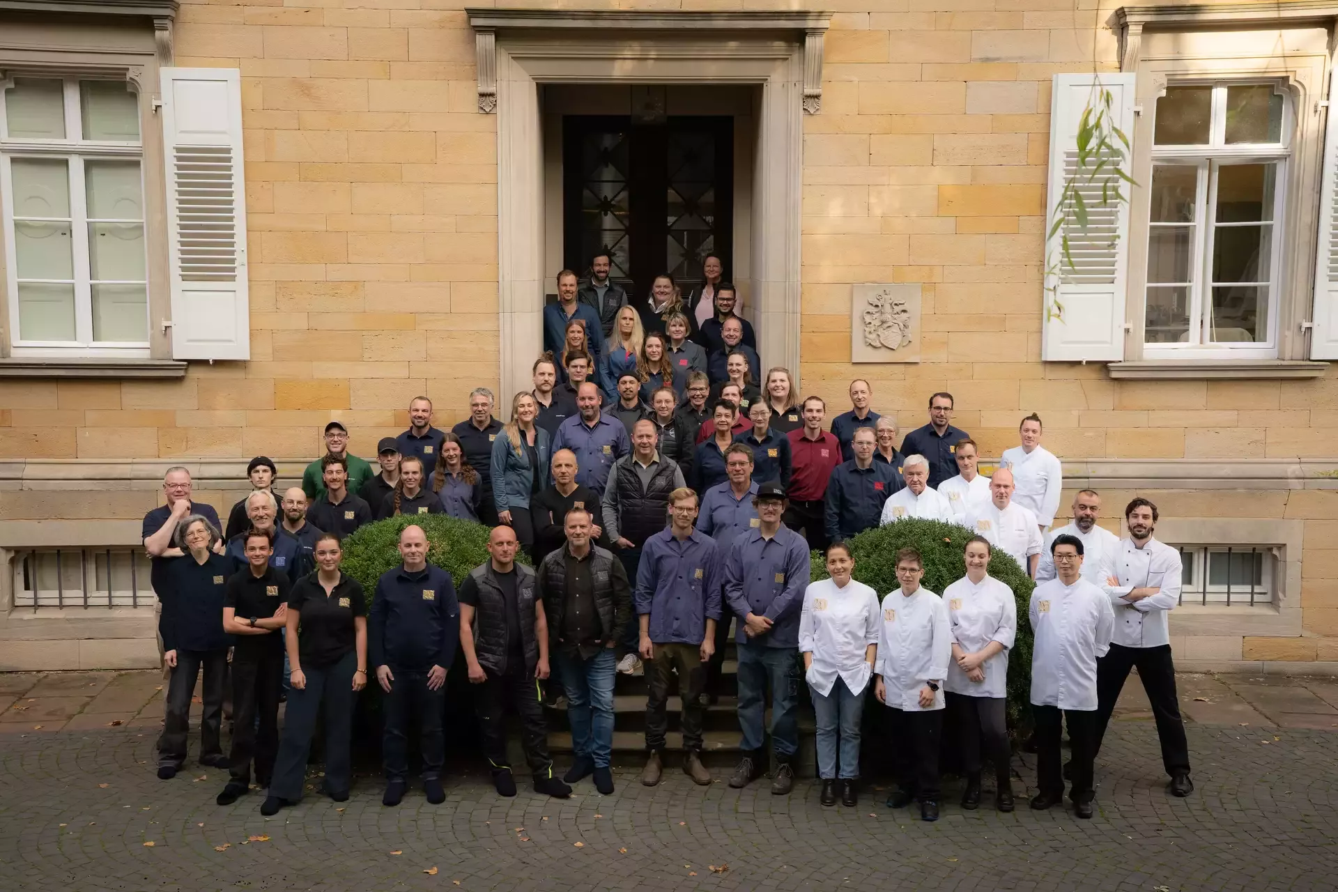 Gruppenfoto des Teams vom Weingut Von Winning vor dem Eingang der historischen Gutsvilla.